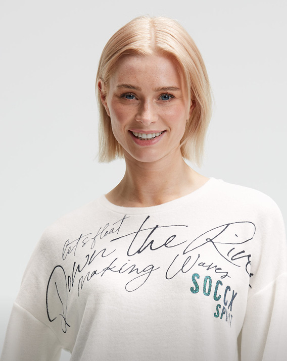 Model trägt weißes Sweatshirt mit Print
