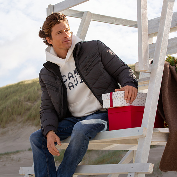 Model trägt Winterjacke und Pullover sitzend