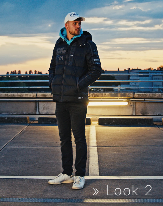 Model trägt Base Cap und Daunenjacke