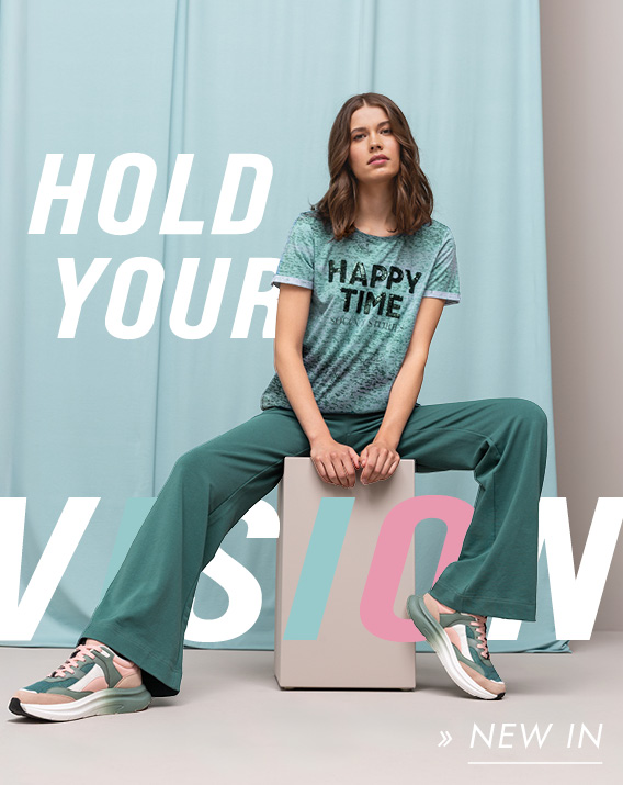 Model trägt T-Shirt und Jogginghose sitzend